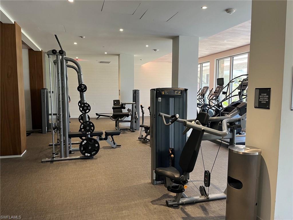Fitness center with cardio machines, strength training equipment, recessed lighting, and carpet flooring
