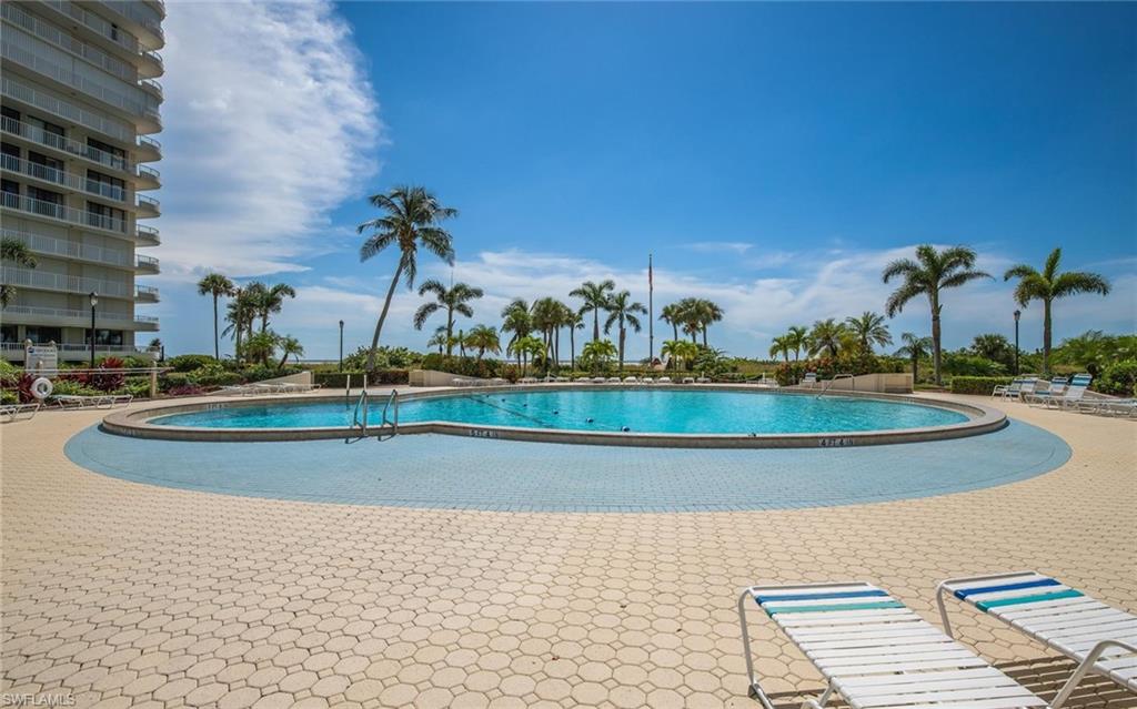 Curved swimming pool surrounded by a paver deck