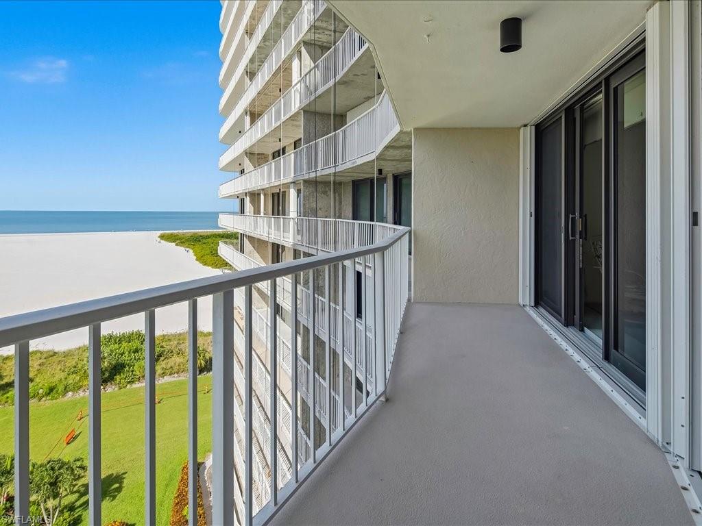 Balcony with a high-rise building exterior, metal railings, and sliding glass doors
