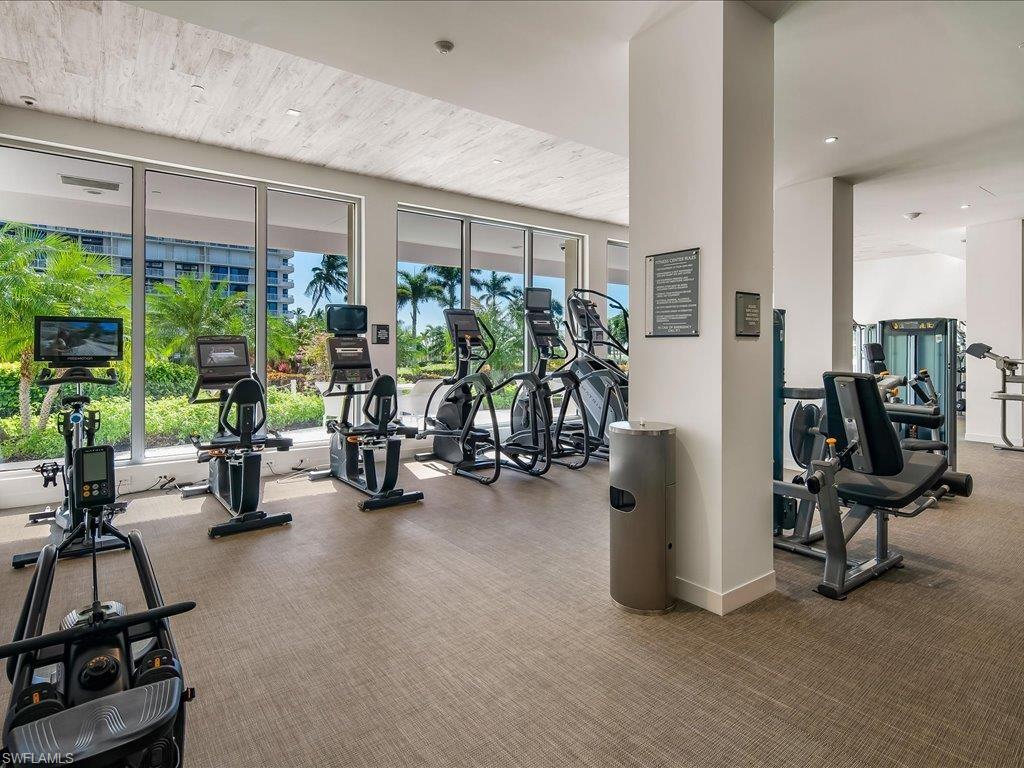 Fitness center featuring multiple exercise machines, full-height windows, recessed lighting, and textured carpeting