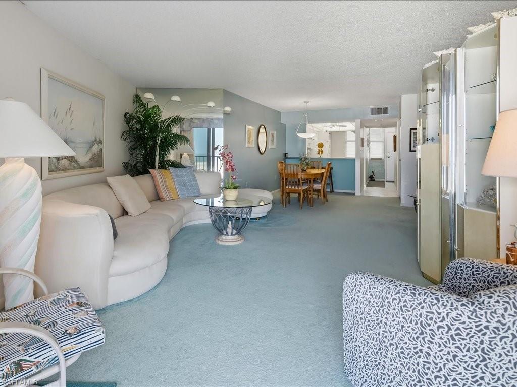 Open-concept living area with light-colored carpeting