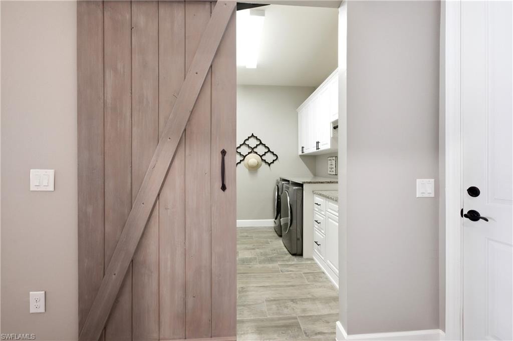 Entrance to laundry room with wood-finish barn door entry