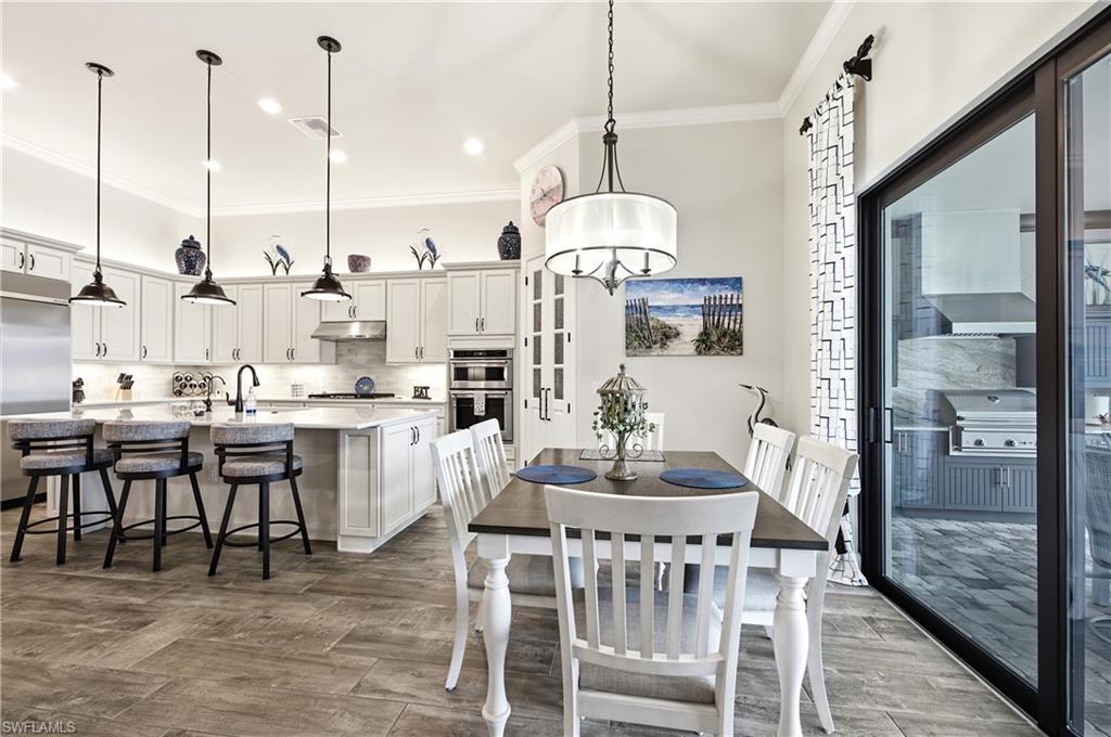 Open-concept kitchen and dining area featuring a kitchen island with seating, pendant lighting, and built-in appliances