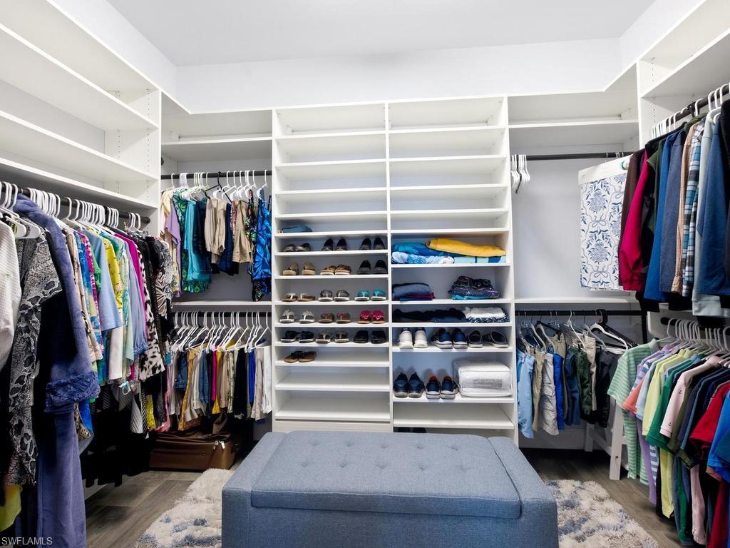 Primary custom closet with extensive shelving, multiple hanging rods