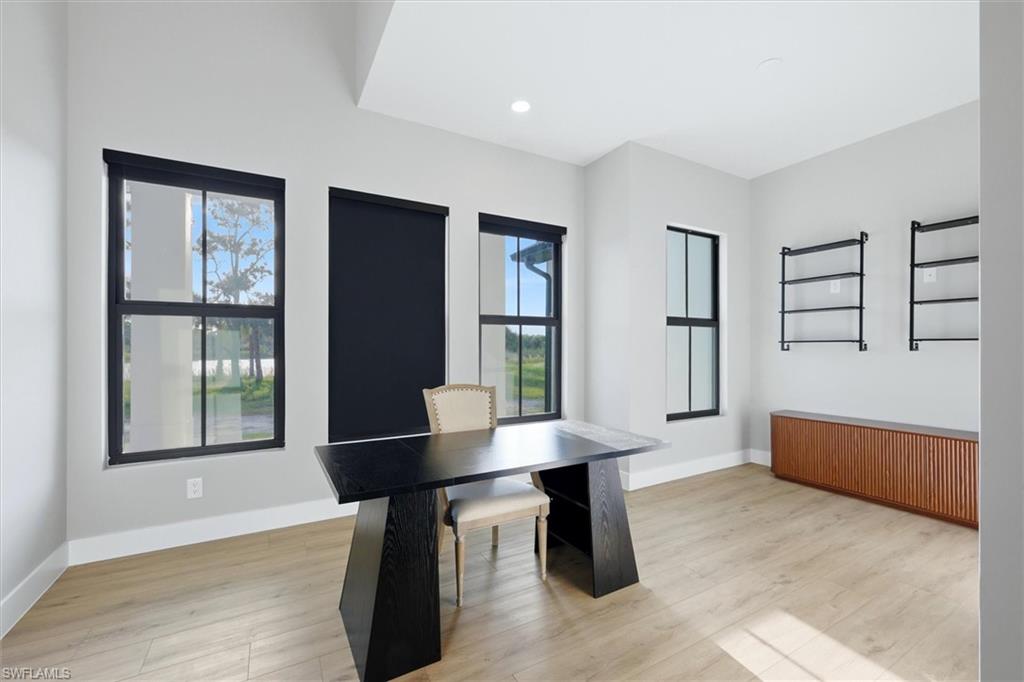 Recessed lighting, light wood-finish flooring, multiple windows, and a built-in wood-finish cabinet