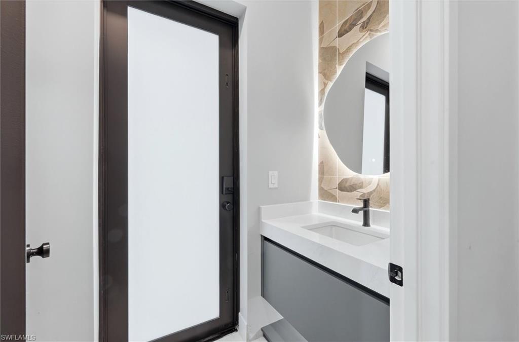 Modern bathroom featuring a floating vanity with white quartz countertop, rectangular vessel sink, and matte black wall-mounted faucet