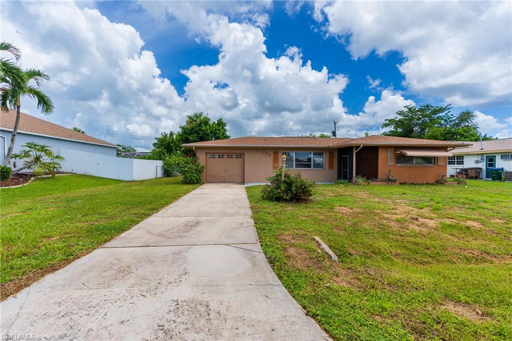 Single-story residence featuring a concrete driveway, attached garage, and prominent front windows