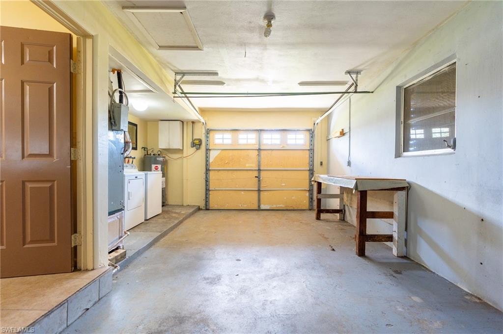 Concrete flooring, panel door, visible window, overhead lighting, garage door with upper window panes