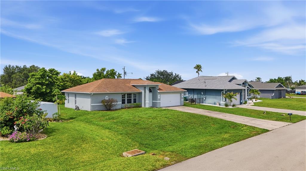 Single-story residence with a light gray exterior, featuring a brown shingle roof and an attached two-car garage