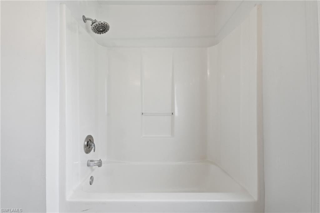 White tub and shower combination with chrome fixtures
