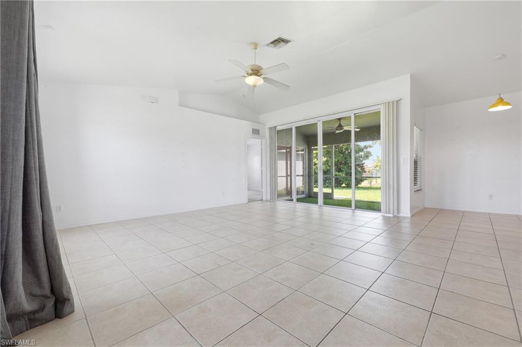 Vaulted ceiling, ceiling fan, tiled flooring, sliding glass doors, and screened-in patio