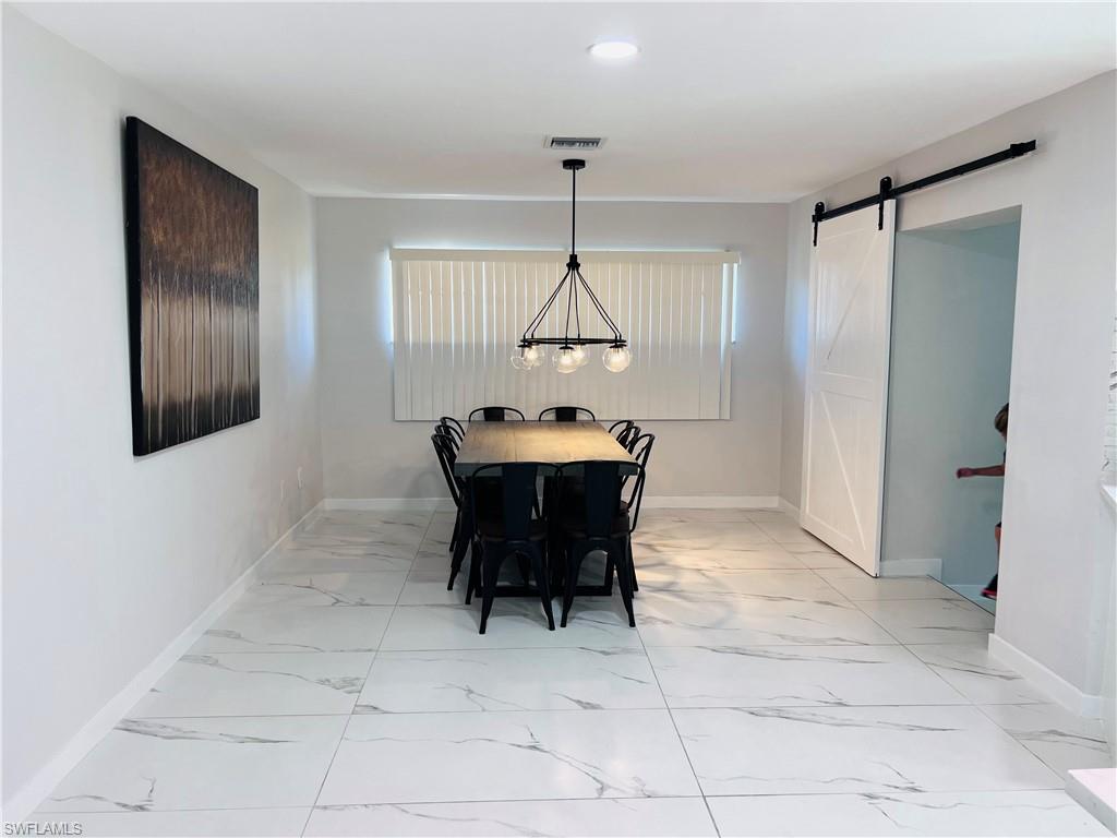 Expansive multi-panel sliding glass doors open to a screened lanai with a swimming pool