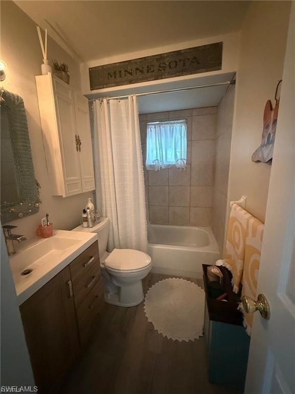 Bathroom featuring a built-in bathtub with tiled surround, wood-finish flooring, and a vanity with an integrated sink and wood-finish cabinetry
