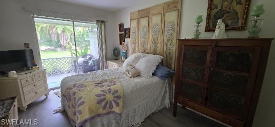 Sliding glass doors opening to a private patio with lattice railing, wood-finish flooring, and light-colored wall paint