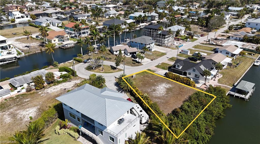 Aerial view of residential area featuring a nearby body of water and property boundaries highlighted