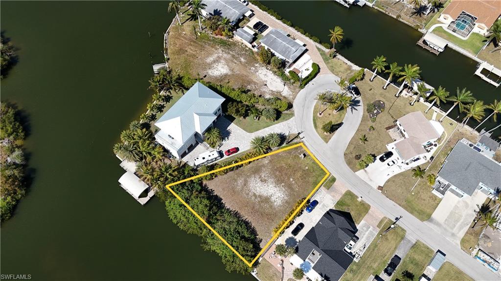 Aerial perspective of suburban area featuring a large body of water and property parcel outlined