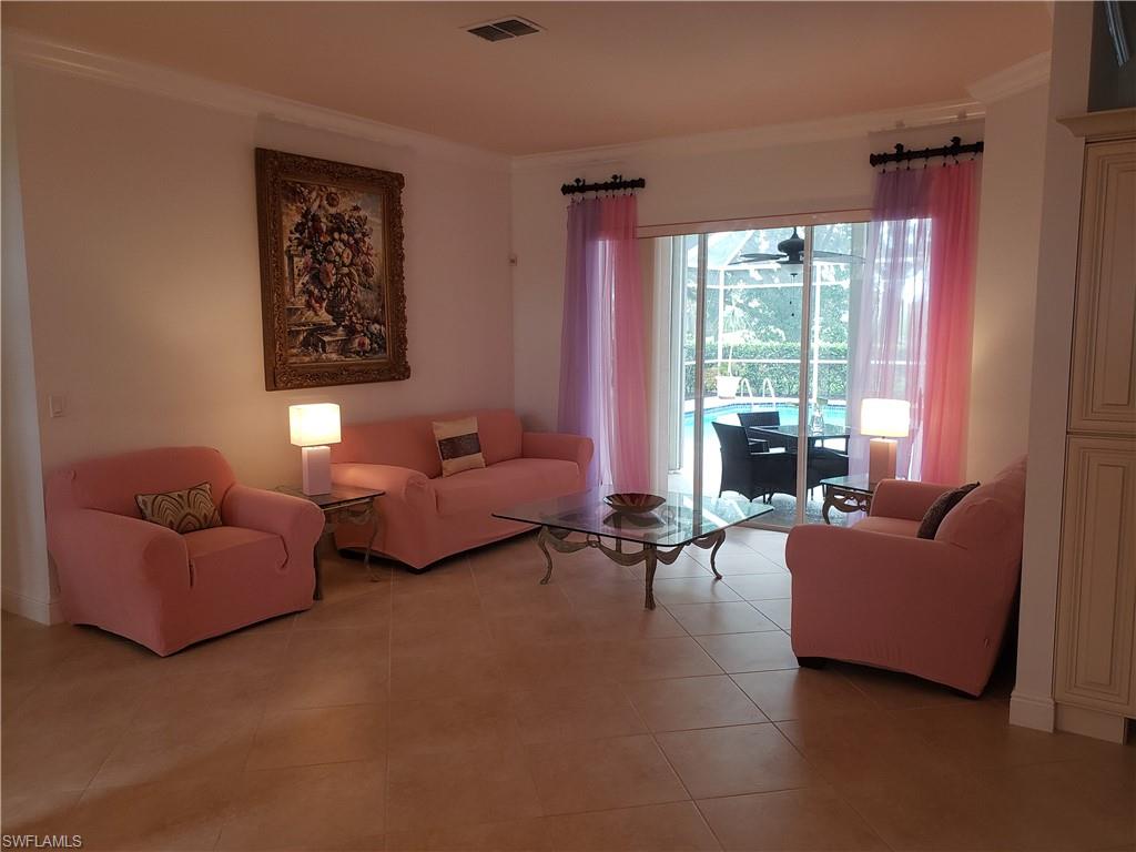 Tiled family room with crown molding and pool view
