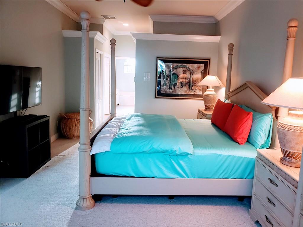 Carpeted bedroom with ornamental molding