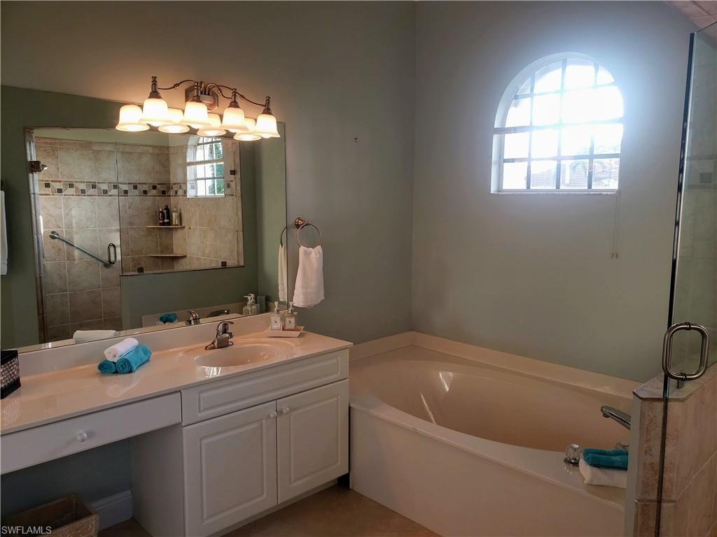 Bathroom featuring vanity and separate shower and tub