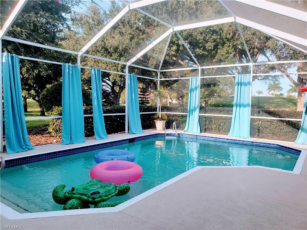 View of pool featuring lanai enclosure and a patio area
