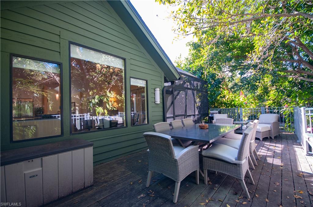 Wooden terrace with a lanai and outdoor dining area