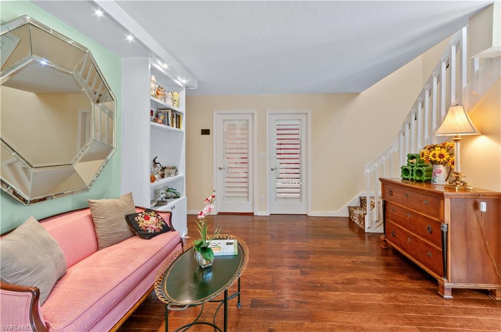 Living area featuring stairs and dark wood-style floors