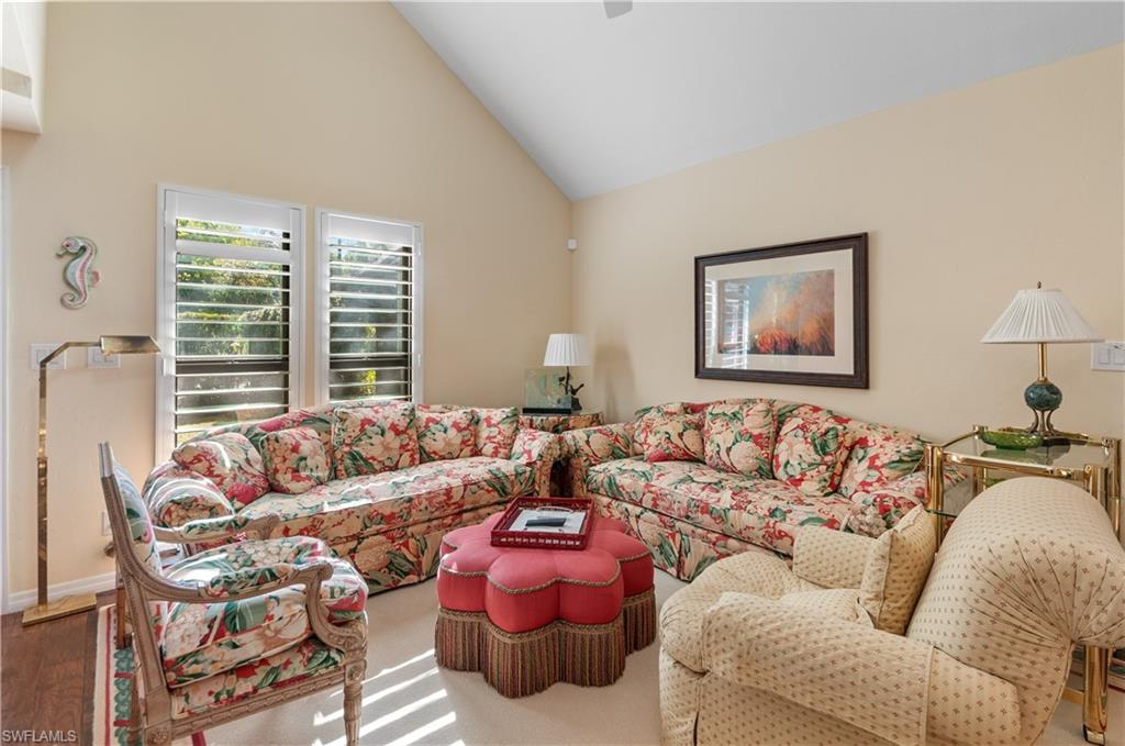 Living room with high vaulted ceiling and baseboards