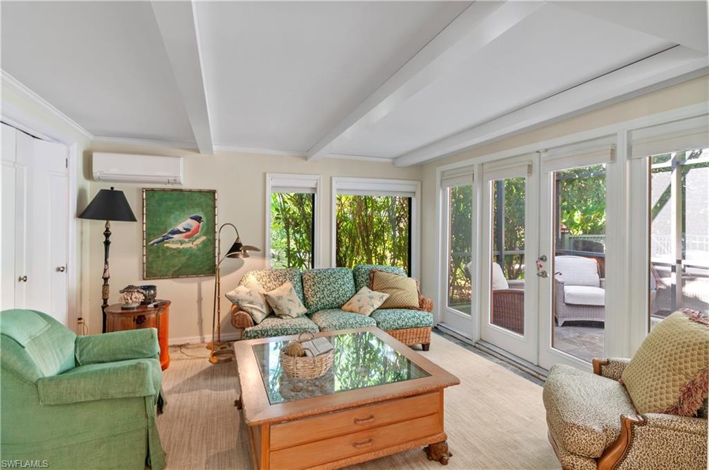 Sunroom / solarium with french doors, beam ceiling, and a wall mounted AC