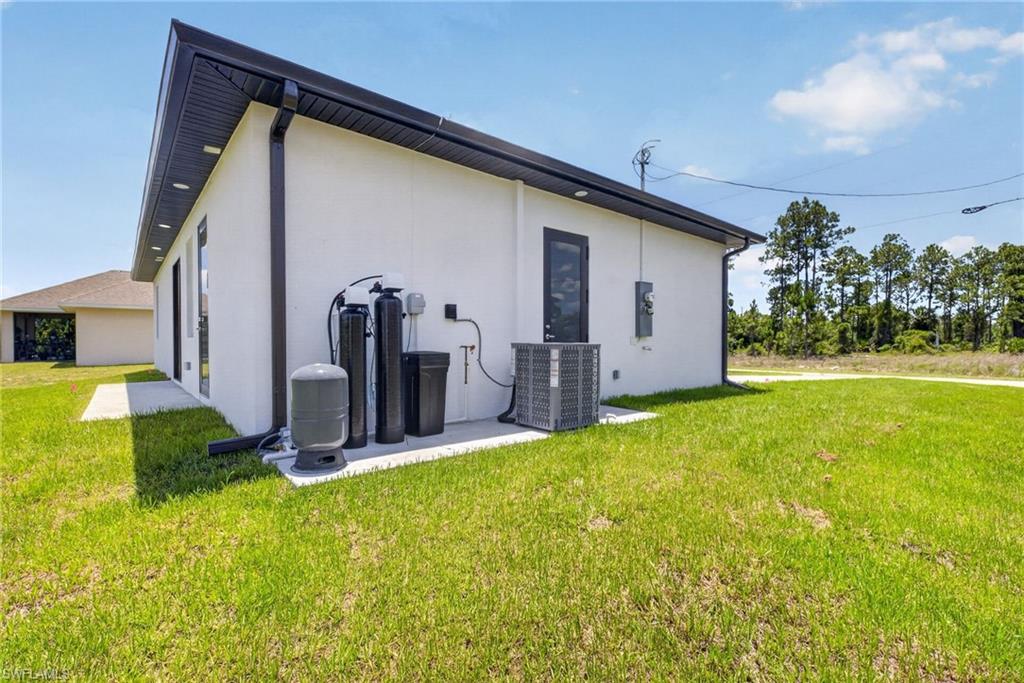 Modern home exterior showcasing a clean-lined architectural design with dark-trimmed roofline and white composite siding