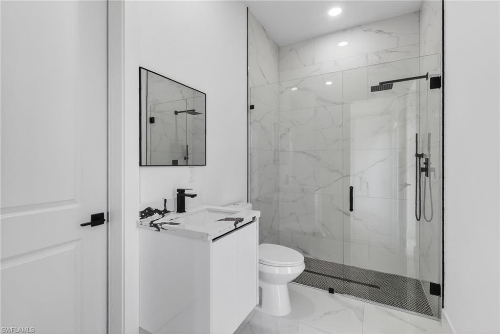 Walk-in shower with clear glass enclosure and black fixtures