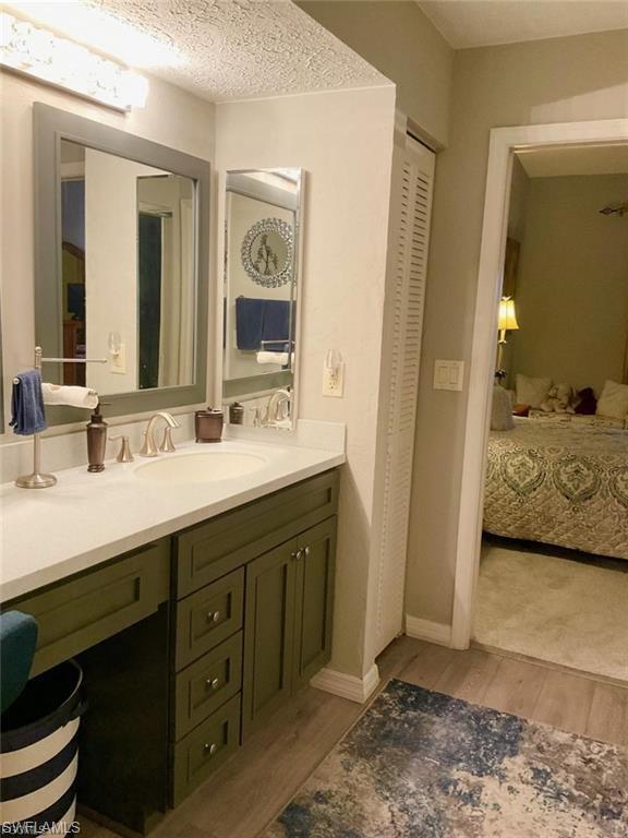 Dual vanity with a white countertop and olive green cabinetry