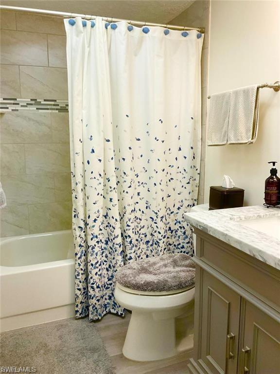 Spa-inspired bathroom featuring a marble-topped vanity with integrated sink, brushed nickel hardware, and soft taupe cabinetry