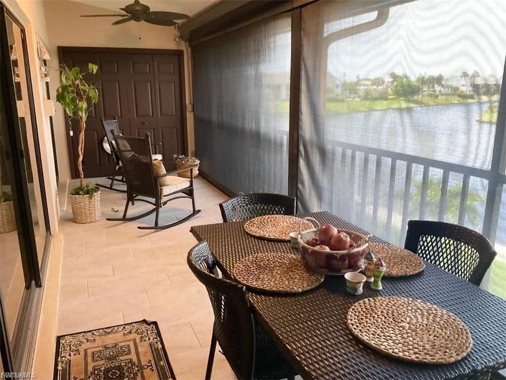 Screened lanai with tile flooring, ceiling fan, and waterfront outlook