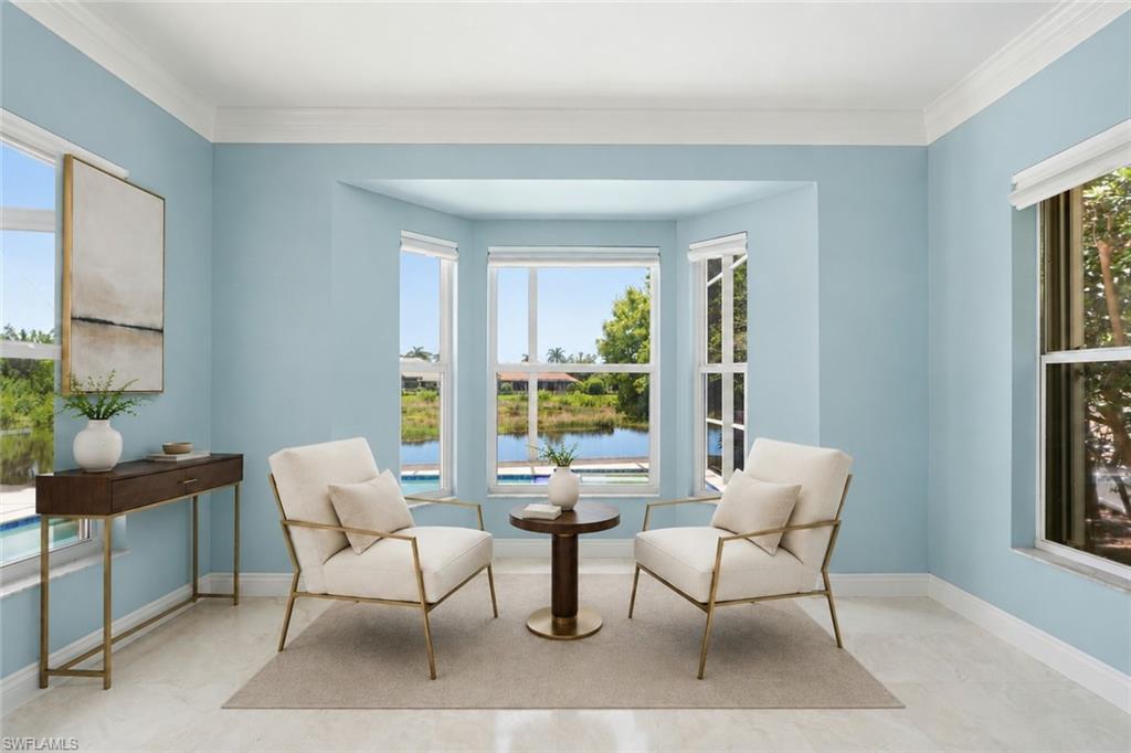A light-filled sitting room surrounded by oversized windows with tranquil pool and water views.