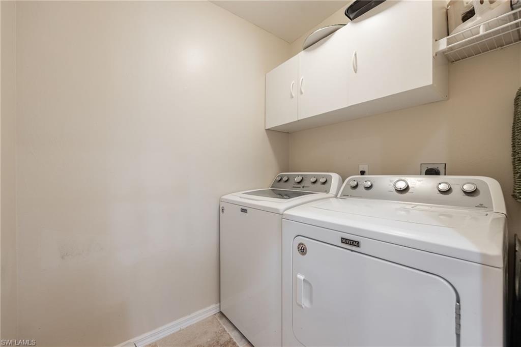 White upper cabinetry with ample storage, wire shelving, and a neutral wall color