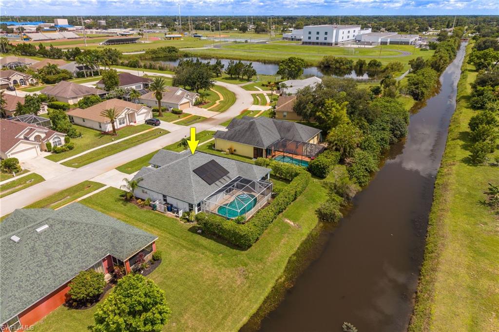 Property featuring a screened-in pool, solar panels, and a concrete paver patio