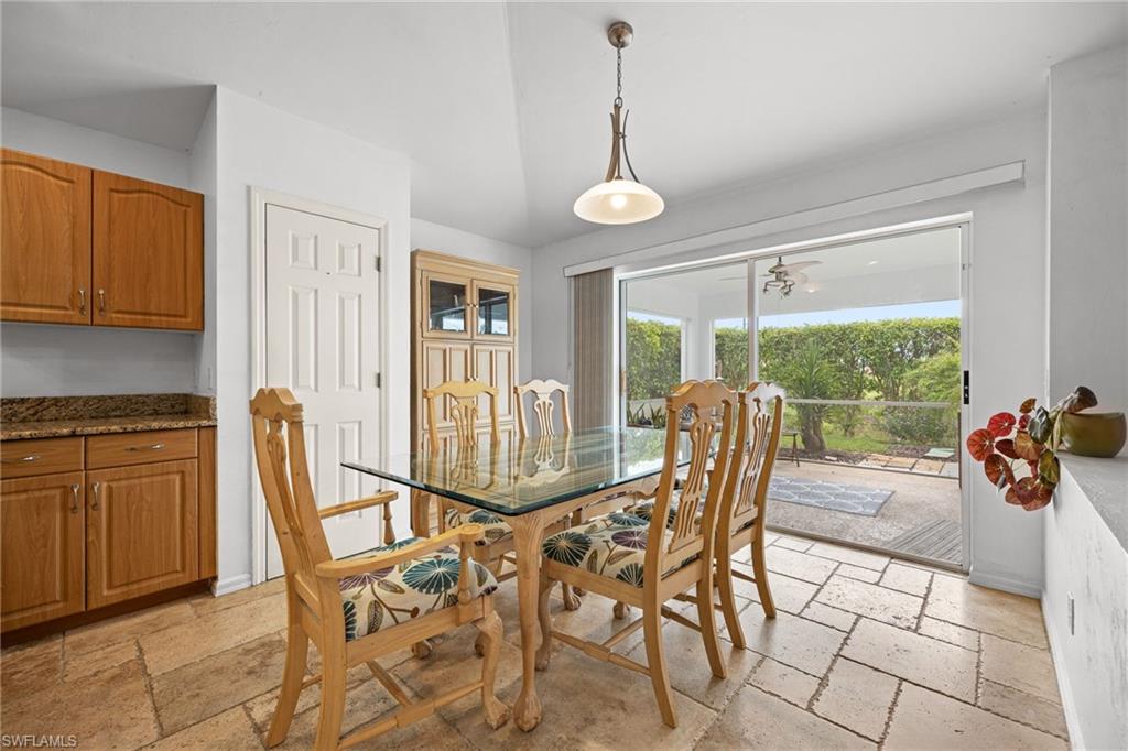 Bright dining area featuring a wood-finish table, upholstered chairs with carved wood detailing, and ceramic tile flooring