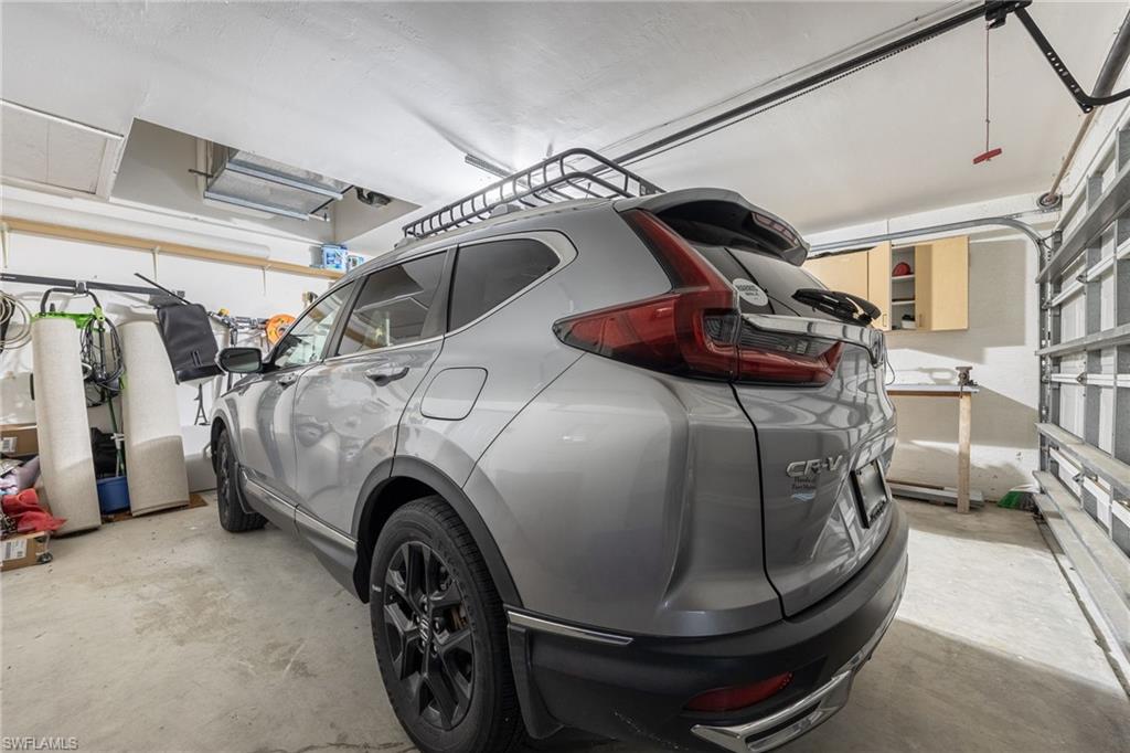 Garage with concrete flooring, overhead lighting, and built-in cabinetry