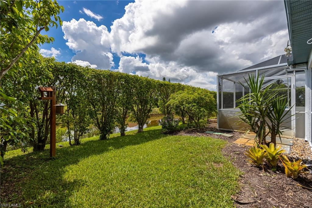 Screened enclosure, green lawn, established landscaping, stepping stone pathway, and mature hedges