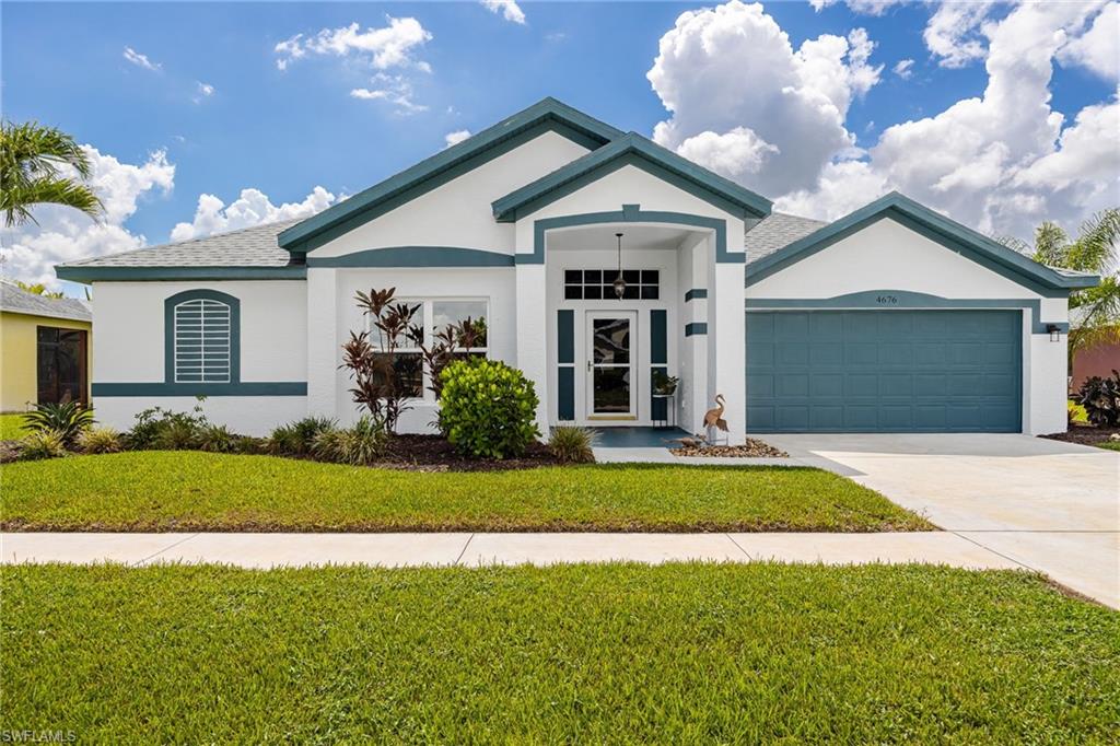 Charming single-story residence featuring a gabled roofline with teal trim accents, white exterior finish, and a centered entry.