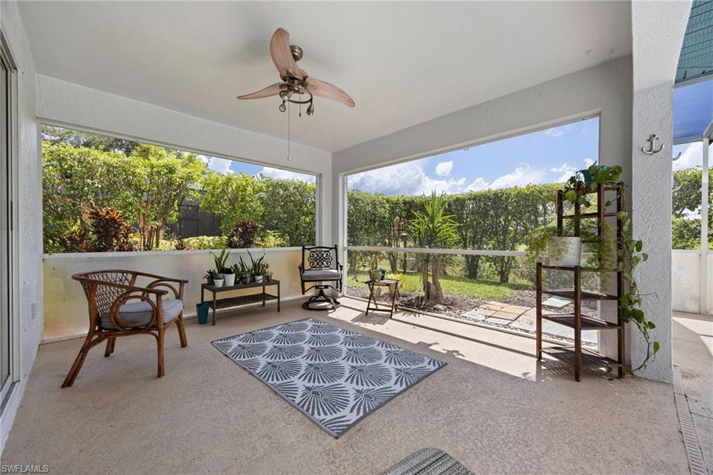 Spacious covered patio with ceiling fan, screened enclosure, and concrete flooring