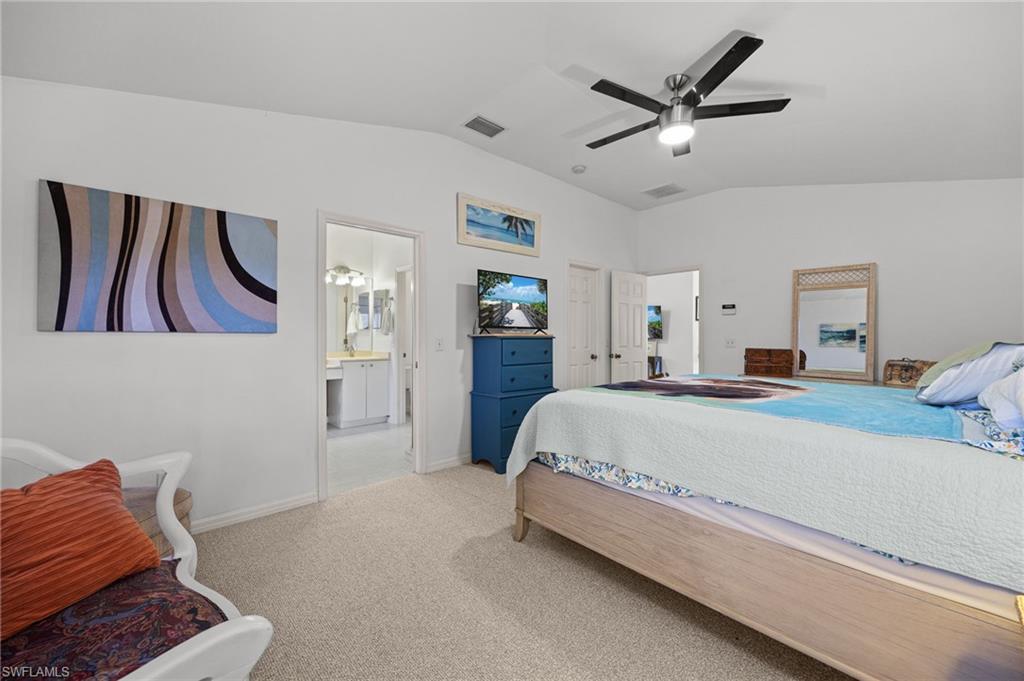 Vaulted ceilings, a ceiling fan with integrated lighting, and carpeted flooring