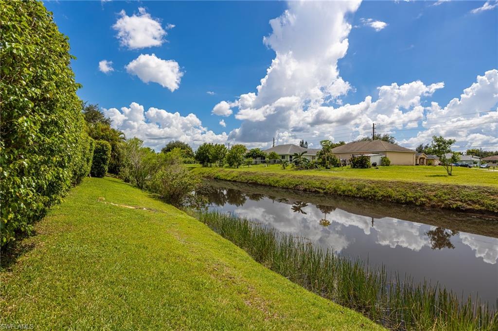 Manicured lawn with a privacy hedge and canal frontage