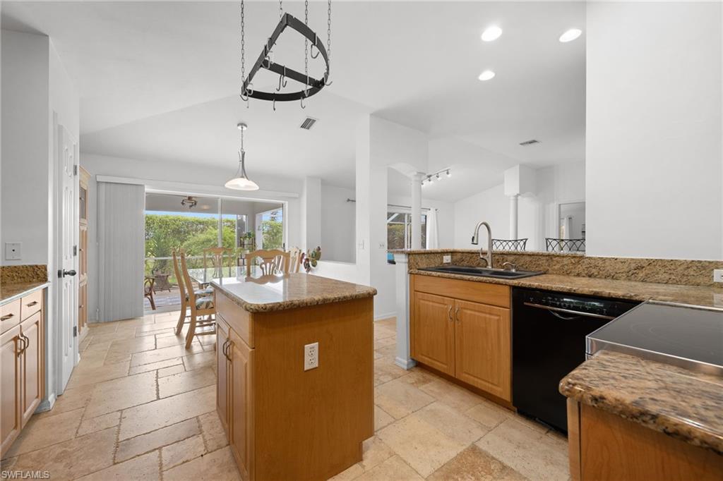 Spacious kitchen featuring dual islands with wood cabinetry and stone countertops, stainless steel appliances, recessed lighting, and pendant fixtures