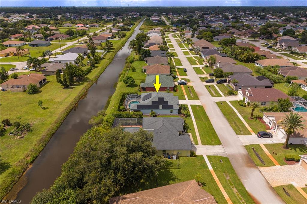 Waterfront residence positioned on a canalside lot with mature landscaping and lush grounds