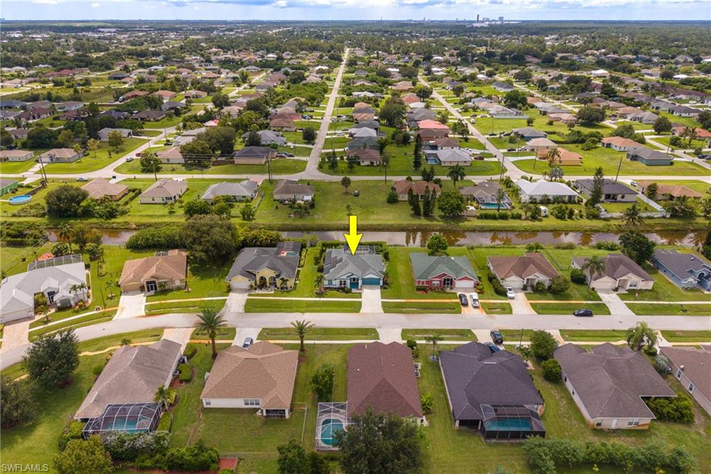 Aerial view showcasing a well-appointed residential community with mature landscaping, manicured lawns, and tree-lined streets