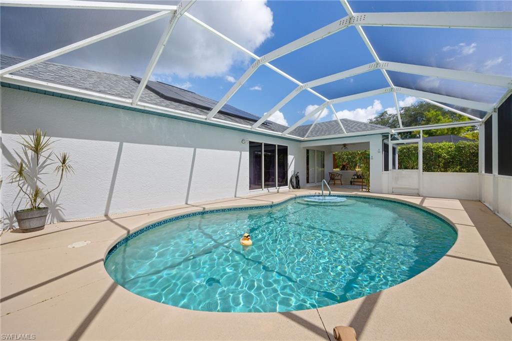 Resort-style oval pool with crystal-clear turquoise water, surrounded by expansive stamped concrete decking