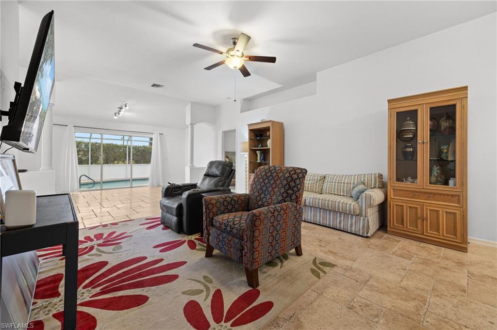 Bright, open living area showcasing wood-finish flooring, recessed lighting, and a ceiling fan