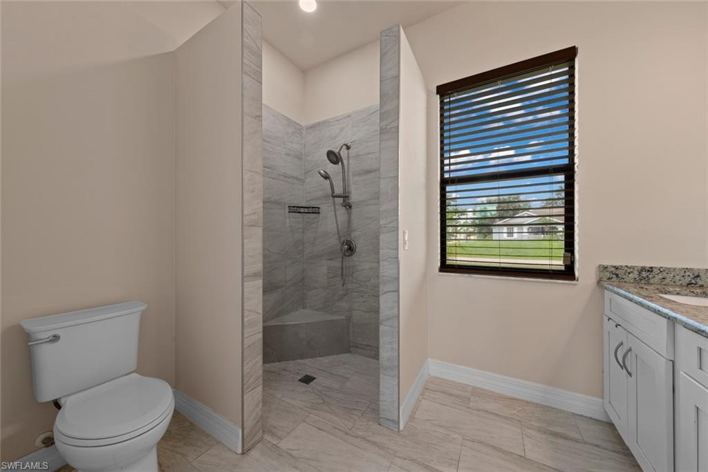 Walk-in shower with tiled walls, integrated bench, and dual showerheads