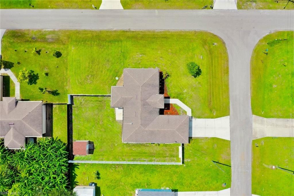 Aerial view showcasing a substantial residential lot with landscaping and manicured lawn